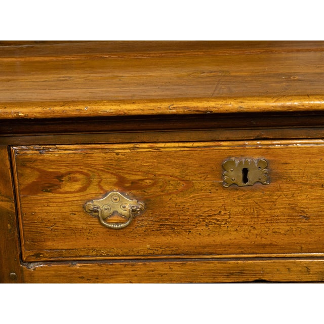 An English Georgian period pine dresser from the early 19th century, with open shelves, Doric style pilasters, petite door...