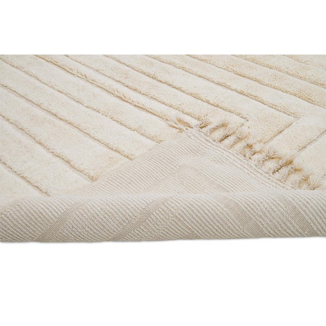 Elegant hand-knotted wool rug in soft Ivory tones. Featuring a refined linear pattern, this versatile piece brings warmth...