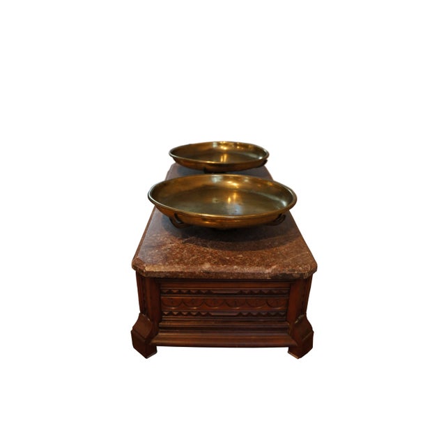 Carved wooden base and red granite top with two 9" diameter brass pans. The bottoms of the pans have a marking that reads:...