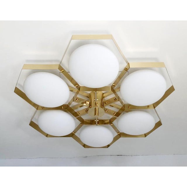Italian midcentury flush mount with six matte white Murano glass shades mounted on solid brass frame in lacquered polished...