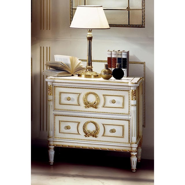 Handcrafted in Italy, this Louis XVI nightstand features a glazed white finish accented with 24-karat gold leaf detailing....