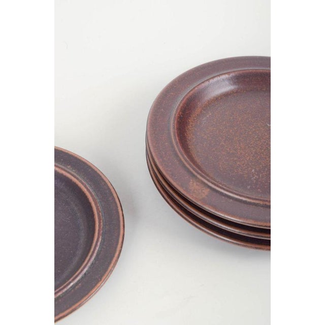 Arabia Finland Plates “Ruska”, 1960/70s. Four smaller plates from the iconic “Ruska” series, crafted in dark brown...