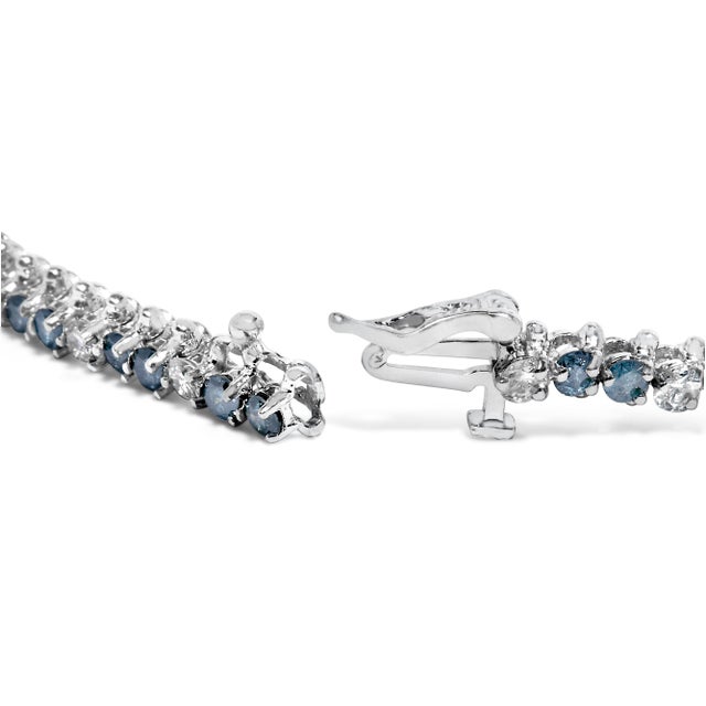 Draped in the luxury of 14K white gold, enhanced with rhodium plating, this tennis bracelet is a parade of precision and...