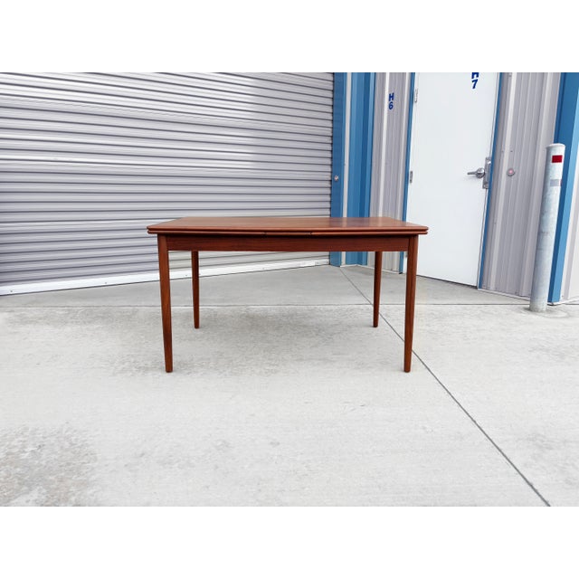 Danish modern teak extension dining table designed and manufactured by AM Møbler in Denmark during the 1960s. Showcasing...
