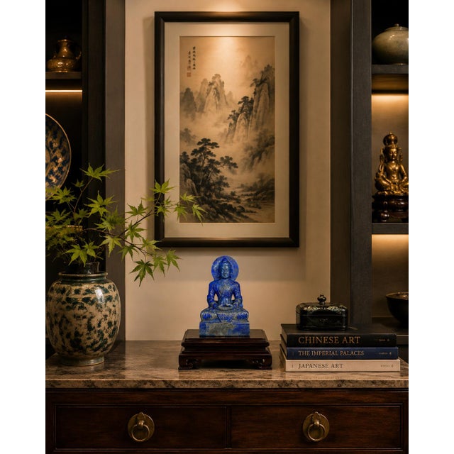 A stately Buddha sculpture, hand-carved from genuine natural lapis lazuli, distinguished by its magnificent deep blue...