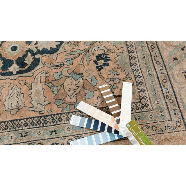 An Antique Persian Meshad Rug with abstract floral and geometric shapes incorporated into a large scale half drop pattern...