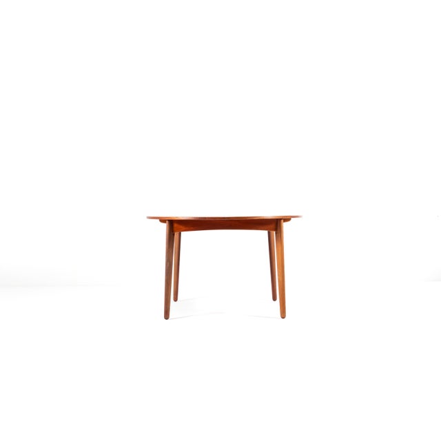 Elegant Danish teak dining table by HP Hansen, featuring two extendable leaves. Beautiful warm teak grain and sculptural...
