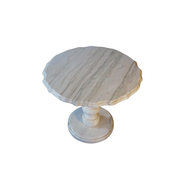 This elegant pedestal table is crafted entirely from solid white marble, showcasing beautiful natural grey veining...