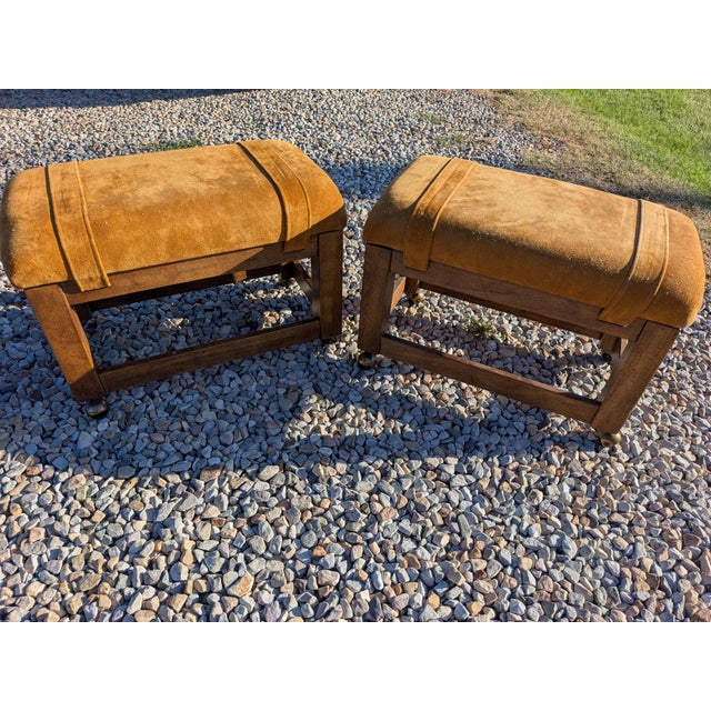 A pair of 1970’s Drexel Heritage suede parsons stools/ottomans in a golden tan color. Parson style frame with rolling...