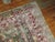 An early 20th century Persian Tabriz rug with a large herati design with raspberry and pink accent colors on a dark green...