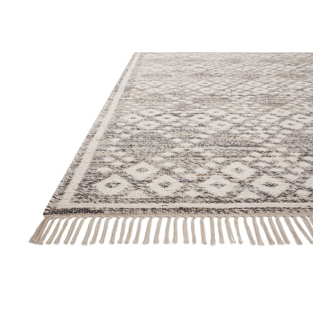 The Rivers Collection by Angela Rose x Loloi is a modern flatweave area rug with a reversible design featuring symmetrical...