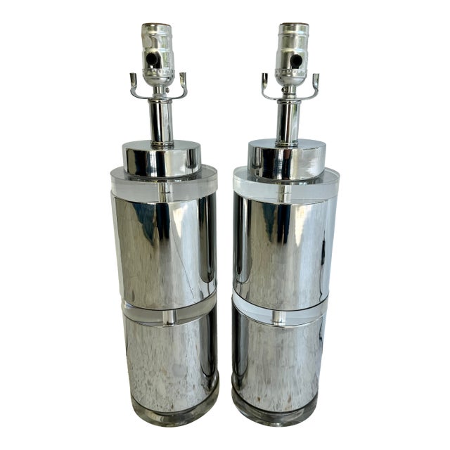 Pair of cylinder table lamps featuring a polished metal with chrome finish and three thick clear discs. They are designed...