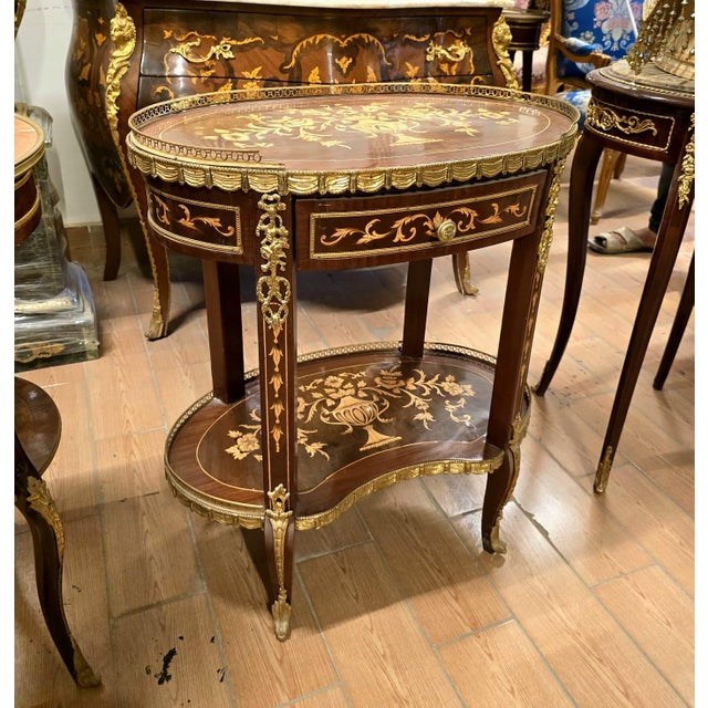 A stunning French Louis XV-style oval side table showcasing exceptional marquetry craftsmanship, elegant proportions, and...