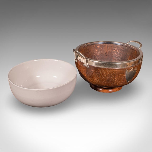 This is an antique presentation prize bowl. An English oak, silver plate and ceramic display or fruit dish, dating to the...