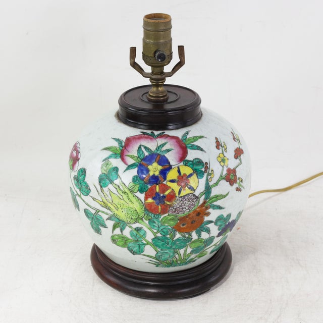 This antique table lamp is crafted from an authentic white porcelain vase featuring a vibrant Famille Rose botanical scene...