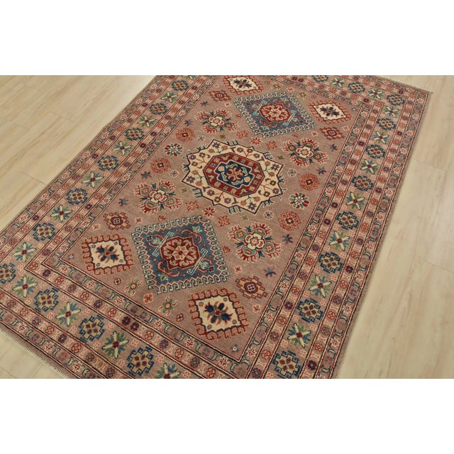 This traditional tribal geometric Caucasian Kazak rug is hand-knotted with an all-wool pile on a cotton foundation. This...