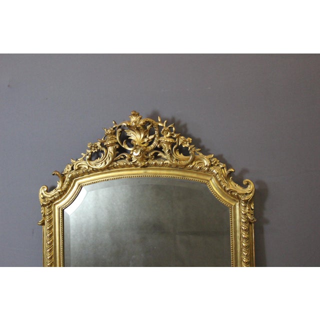 Louis XV style mirror in stucco and giltwood, beveled mirror, decorated with leaves and flowers, late 19th century, in...
