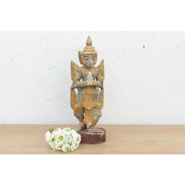 A gentle and welcoming piece of Southeast Asian folk art, this hand-carved wooden figure likely originates from Myanmar....
