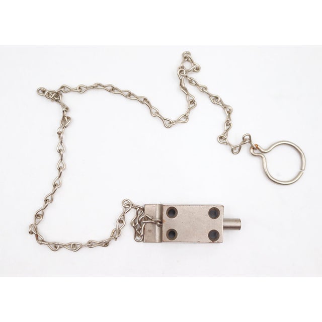 Cabinet latch with a nickel finish and operated by a long chain. These are old new stock, never used. There may be signs...