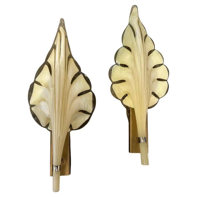 These are 1970s Mid-Century Modern murano glass wall sconces designed by Franco Luce. The sconces feature a striking leaf-...