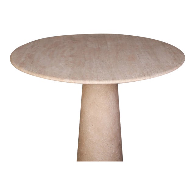 Our travertine dining table features a sturdy pedestal base and a round tabletop, exuding timeless elegance and...