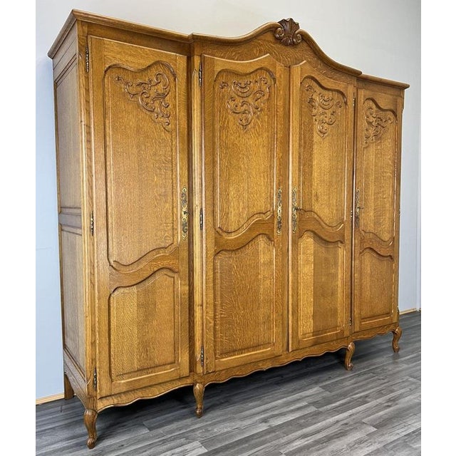 This refined Vintage French Louis style wardrobe presents elegant carved panel doors, a gently shaped cornice with...