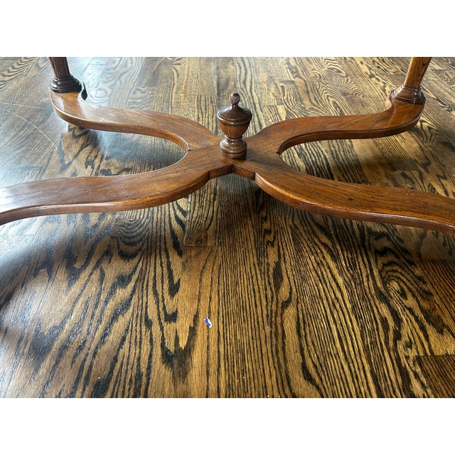 This oak coffee table features the distinctive Ethan Allen design with an elegant oval top, beautifully curved/serpentine...