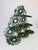 Vintage green metal display stand with three stepped levels and an intricate arrangement of oversized curls and circular...