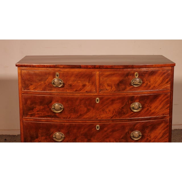 Exquisite bombé mahogany commode from the early 19th century, England. Beautiful flame-like decoration adorns the drawers,...