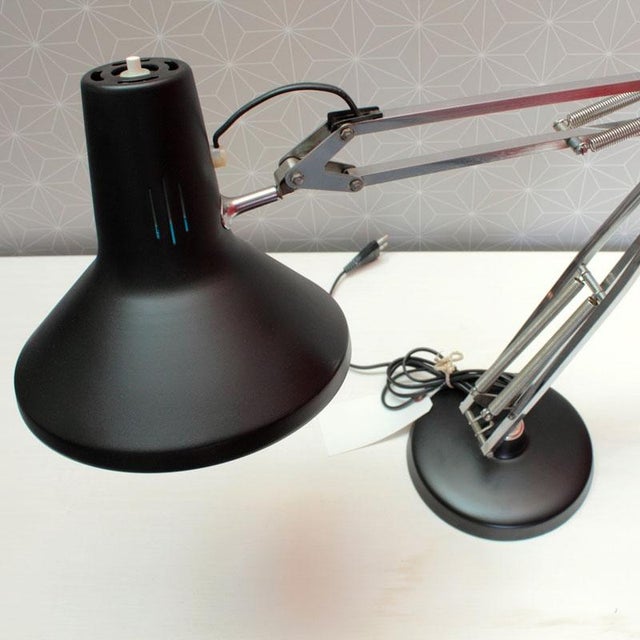 Table lamp from the famous Luxo brand, of the adjustable type with round base and extendable spring arms This piece has an...