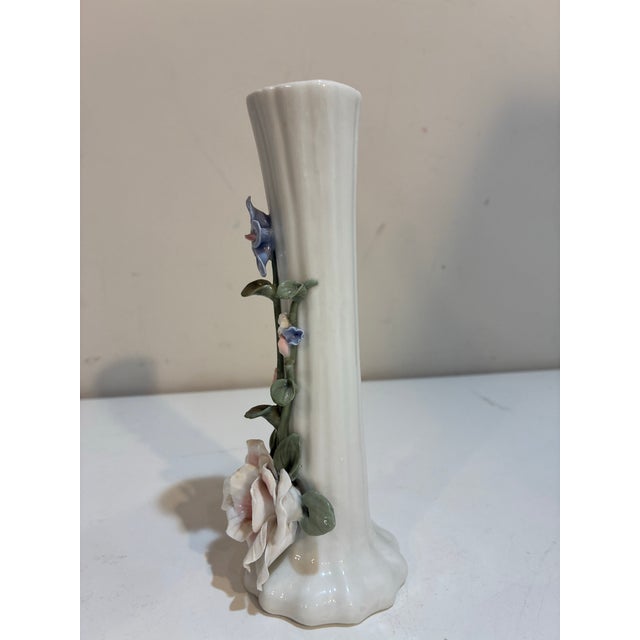 Delicate vintage porcelain bud vase with a slender fluted ivory-white body embellished with dimensional applied flowers...