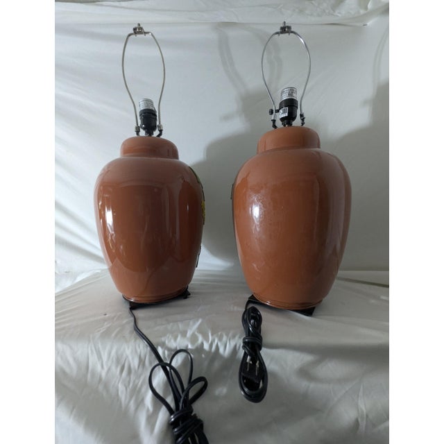 Infuse your space with vibrant charm through this vintage table lamp set, beautifully hand-painted on glass orange bases...