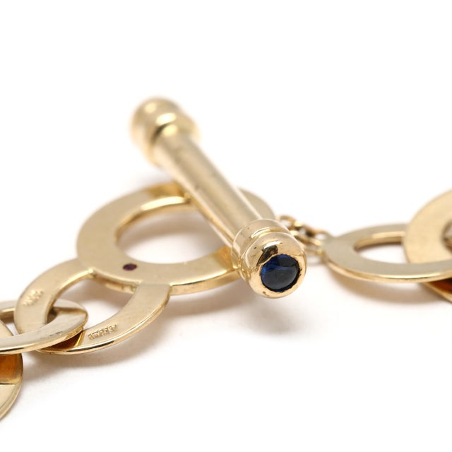 Stones: sapphire, 2 round cab ruby, 1 round Length: 7.25 in Width: .5 in Weight: 8.6 dwts. / 13.3 grams Stamps: "18k...