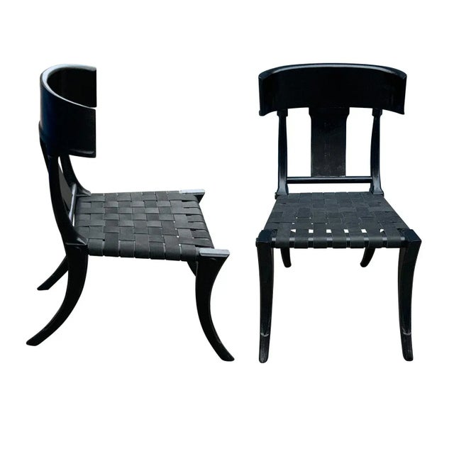 Klismos black dining chairs. The chairs are made of solid alder with a satin finish and leather strapping. The chairs are...