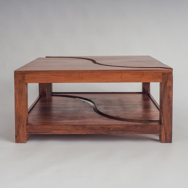 This elegant coffee table, crafted from a warm, rich wood, features a unique design that's both cohesive and versatile....