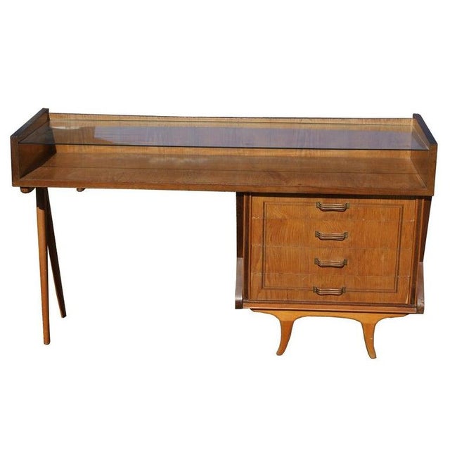 A mid century modern wooden display cabinet from Italy. A glass top over an open display area and four drawers.