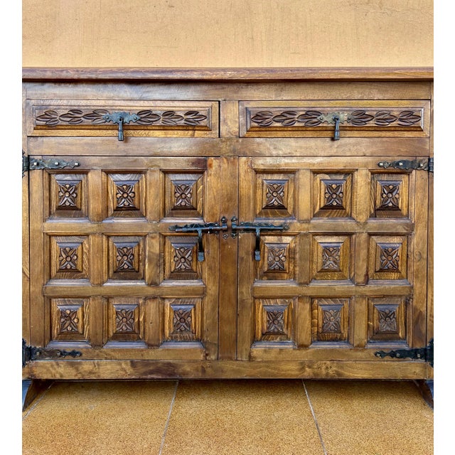 Spanish Revival cabinet dating from the 1940s, crafted in solid wood and inspired by traditional Spanish furniture. The...