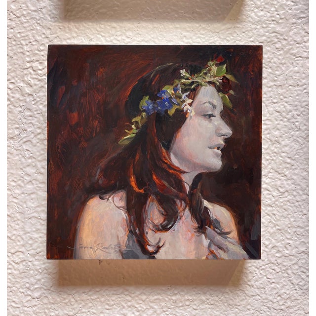 The painting features a serene profile of a woman adorned with a floral crown, capturing a moment of quiet contemplation....