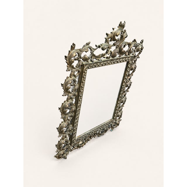 An exceptionally decorative antique tabletop mirror featuring an elaborate Rococo Revival frame, richly cast with...