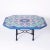 Vintage dining table with an elongated octagon form top featuring colorful Italian tiles with bold floral designs bordered...