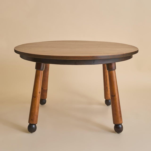 A French dining table from the 1960s, crafted in the manner of Georges Robert. The round solid wood top is constructed...
