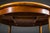 This round extendable dining table is finished in warm teak veneer, showcasing an elegant wood grain and classic mid-...