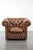 This brown cowhide Chesterfield armchair is a timeless addition to almost any interior and is on casters, making it easy...