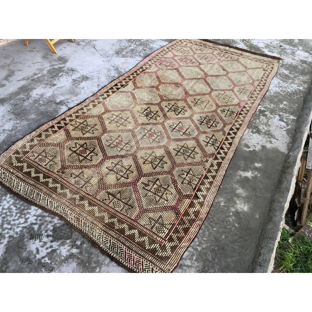 This is a vintage Turkish Anatolian kilim rug from the 1960s. The piece was hand-woven.