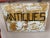 Charming vintage double-sided wooden trade sign, hand-painted with bold black ANTIQUES lettering against an aged ochre...