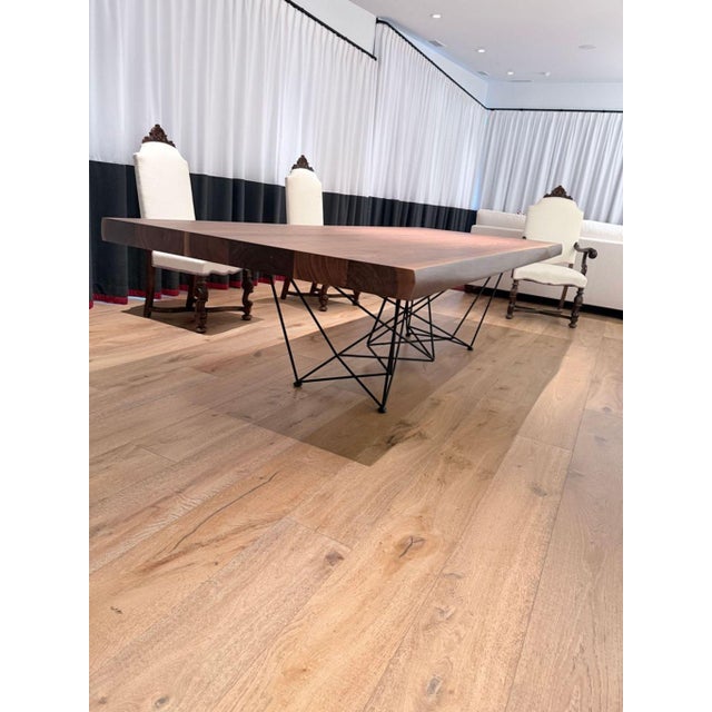 This Cattelan Italia dining table features a solid wood top with a natural edge and a unique grain pattern, giving it a...
