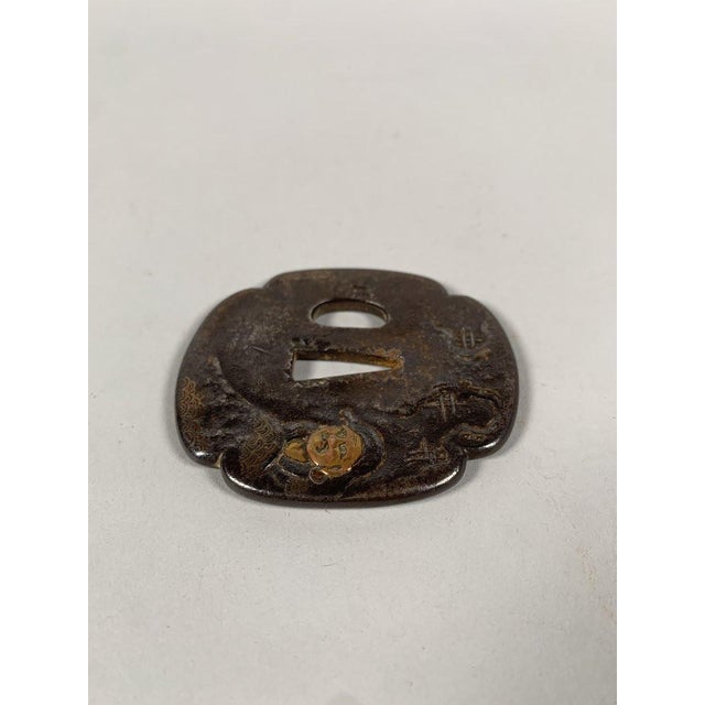 Tsuba Mokko-Gatta, Edo period (1603-1868), wrought iron inlaid with copper and gold, depicting a woman wrapped in a robe,...