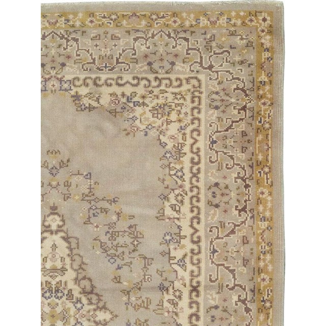 This mid-20th-century Turkish Anatolian long runner presents six elongated floral medallions arranged along a pale...