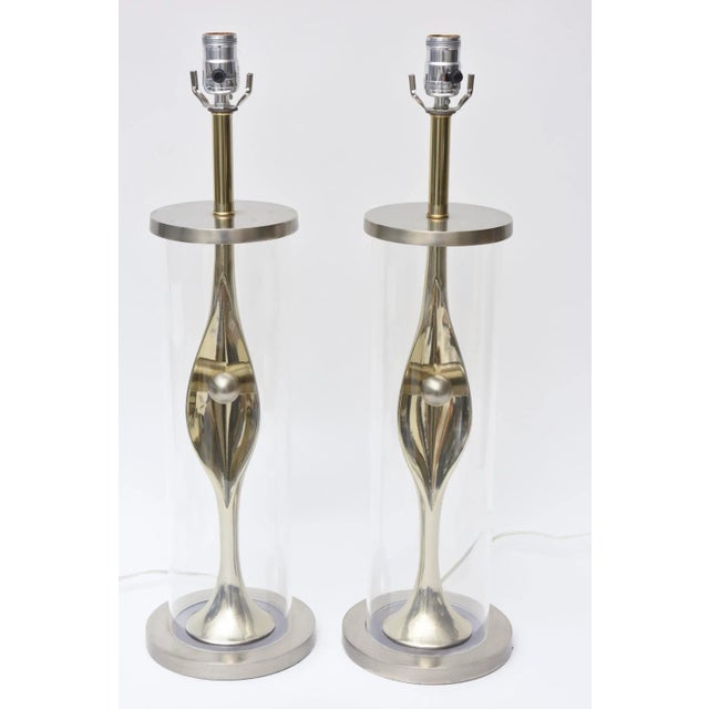 This unusual pair of mid century modern Laurel Lamp Co. mixed metal and lucite table lamps have a sensuality to them. They...