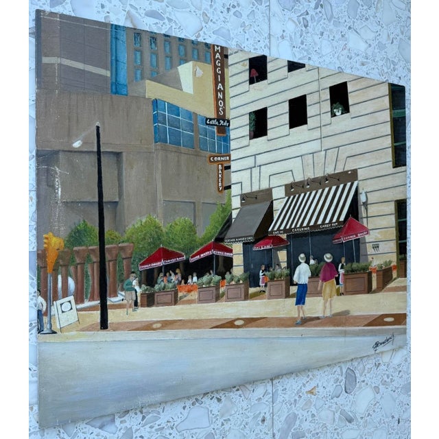 Oil on masonite painting of a street corner featuring a "Maggiano's Little Italy" restaurant and a "Corner Bakery" from...